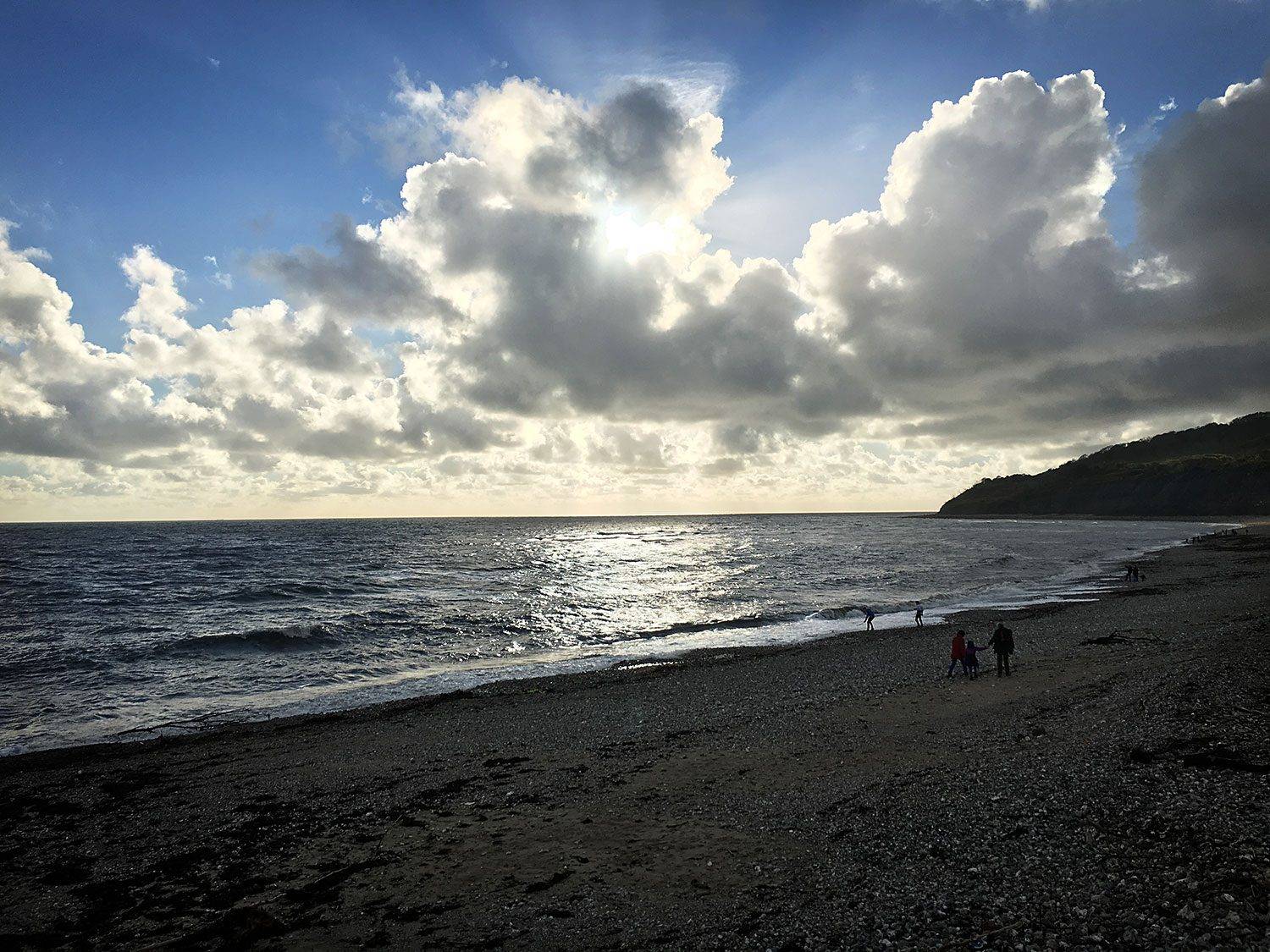 Late afternoon sun and clouds on the beach at Lyme Regis